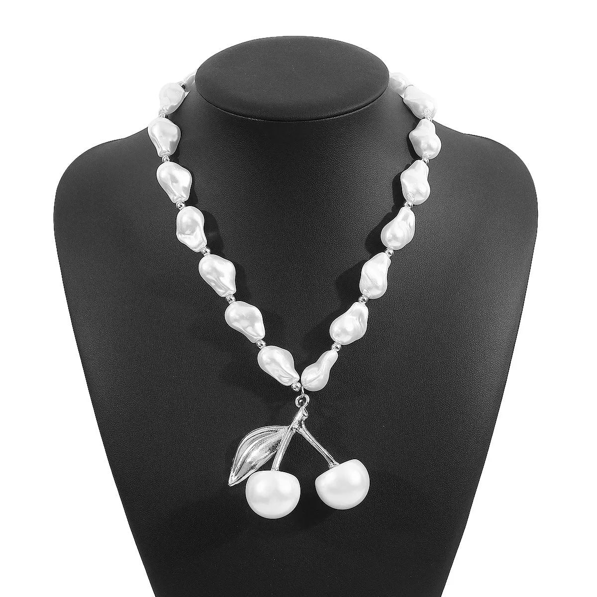 Gold irregular geometric cherry fruit pendant on an adjustable pearl chain necklace for women.