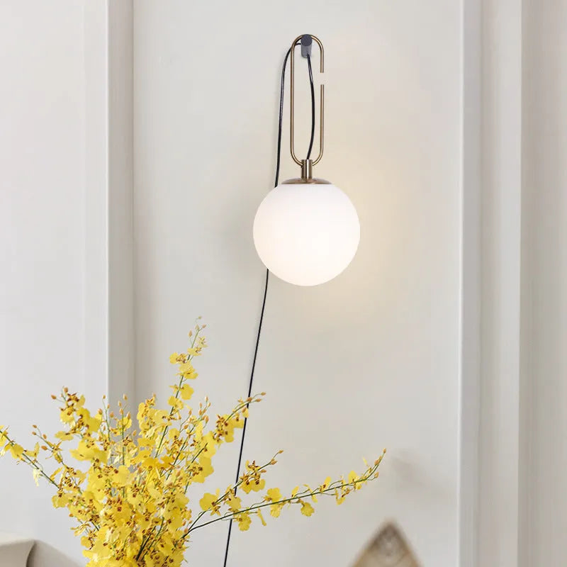 Modern Nordic-style glass wall lamp on a white wall, showing clean lines and translucent glass construction.