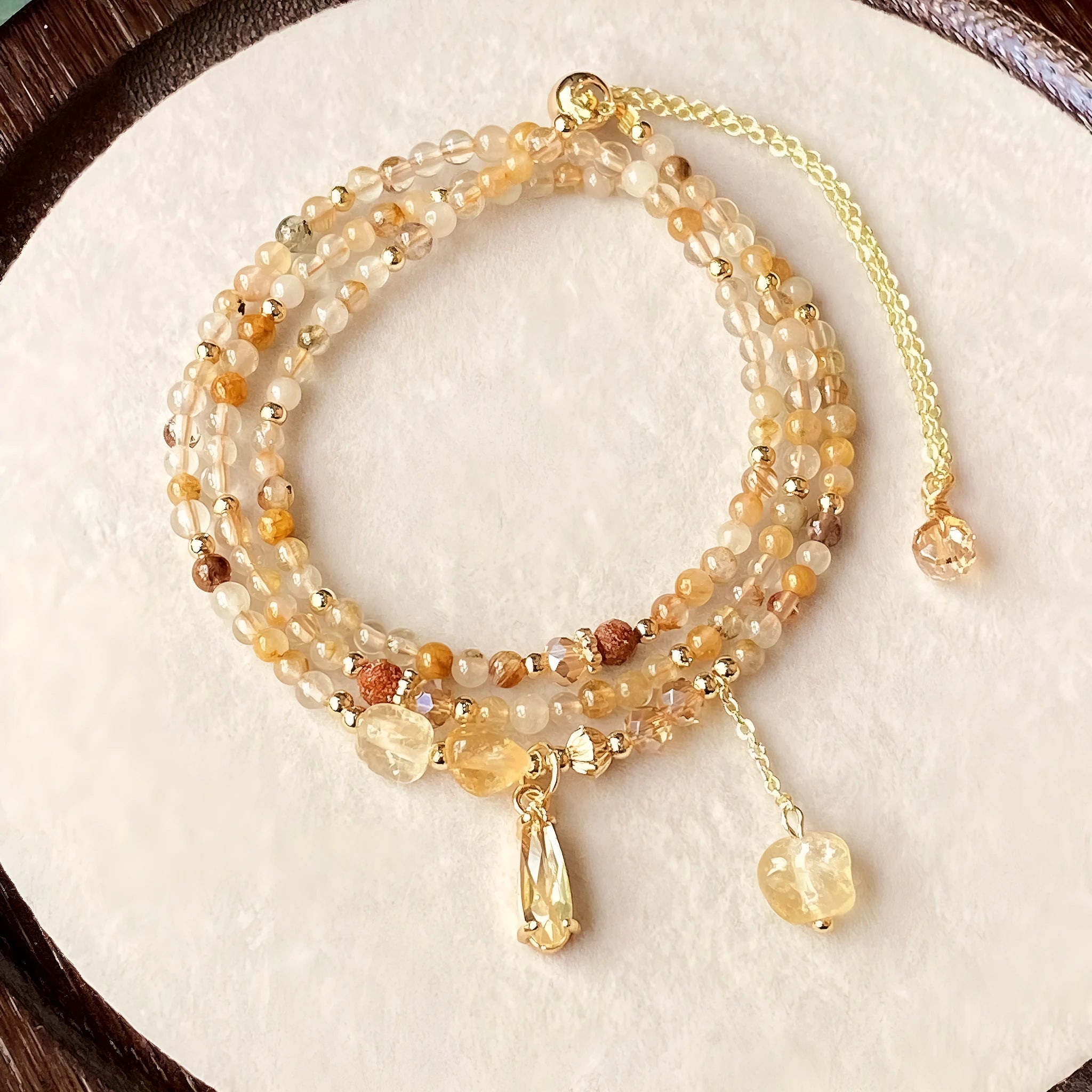 Caramel coloured citrine crystal women's bracelet with multi-layer design and Saturn decorative elements