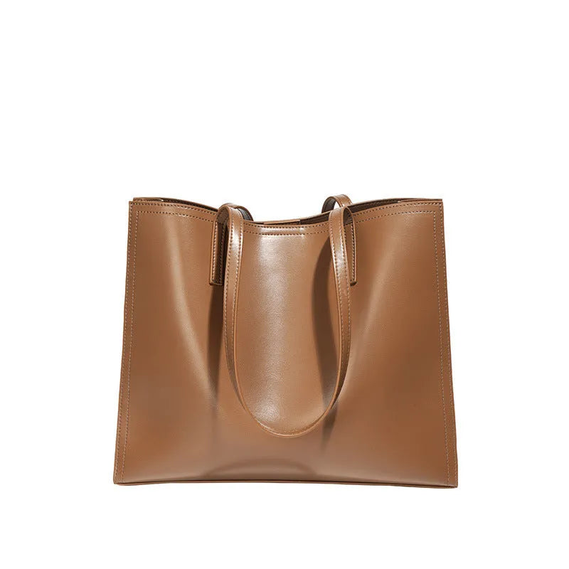 Women's brown genuine leather handbag with multiple internal pockets and single shoulder strap