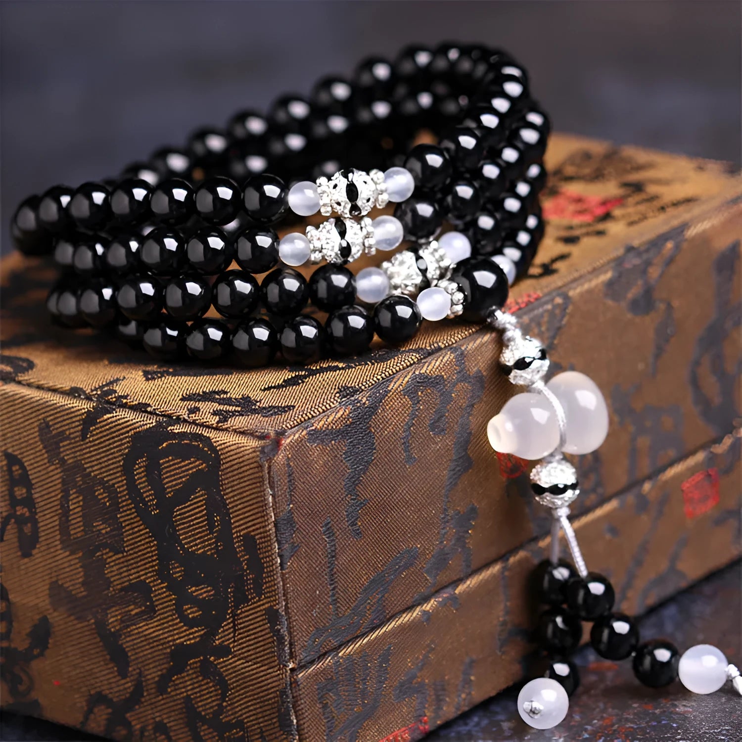 Natural red and black agate 108 bead prayer bracelet with geometric shapes.