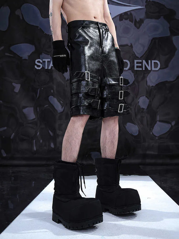 Man wearing black cropped PU leather shorts with a distinctive ring detail on the leg.