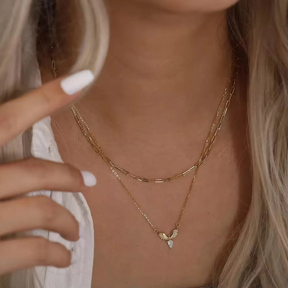 Close-up of an adjustable sterling silver necklace with an eagle pendant on an O-ring chain, showing white gold and yellow gold colour options.