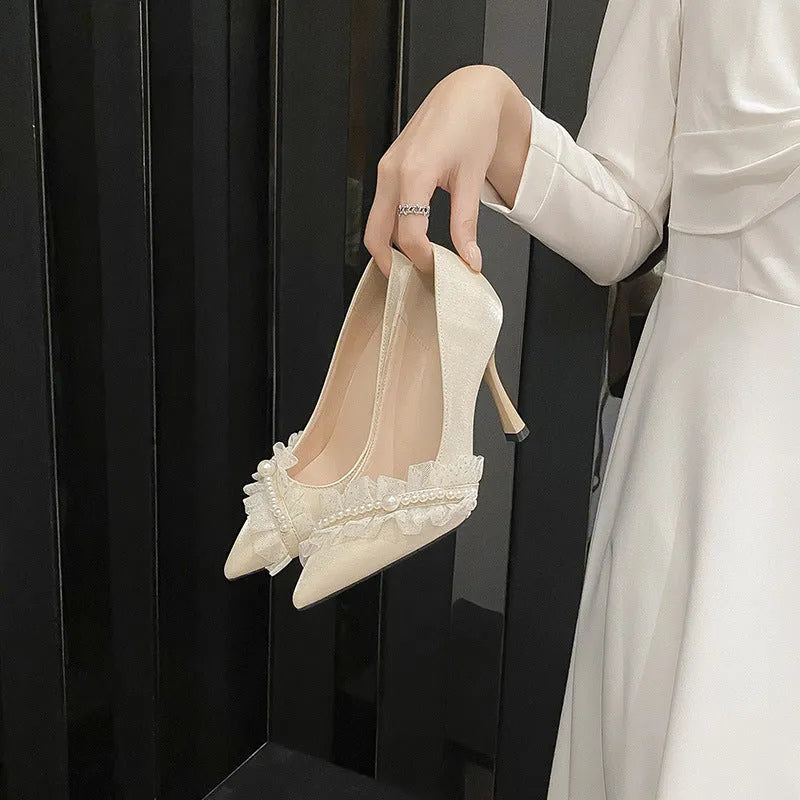Women's stiletto heels in champagne colour with satin upper, pointed toe, and decorative lace and beading