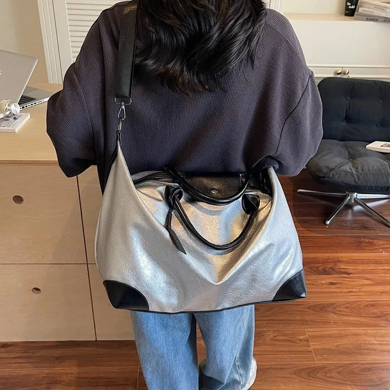 36-55L capacity hand-carry travel bag in black or silver with PU construction and polyester lining