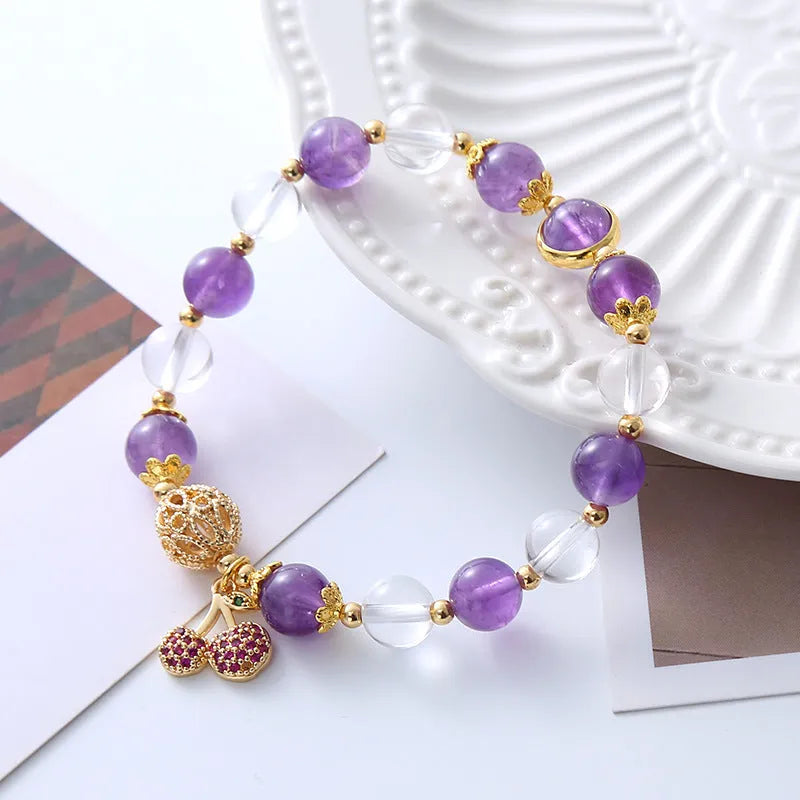 Close-up of a women's purple crystal bracelet with a micro-inlaid cherry flower design on an adjustable band.