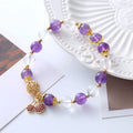 Close-up of a women's purple crystal bracelet with a micro-inlaid cherry flower design on an adjustable band.