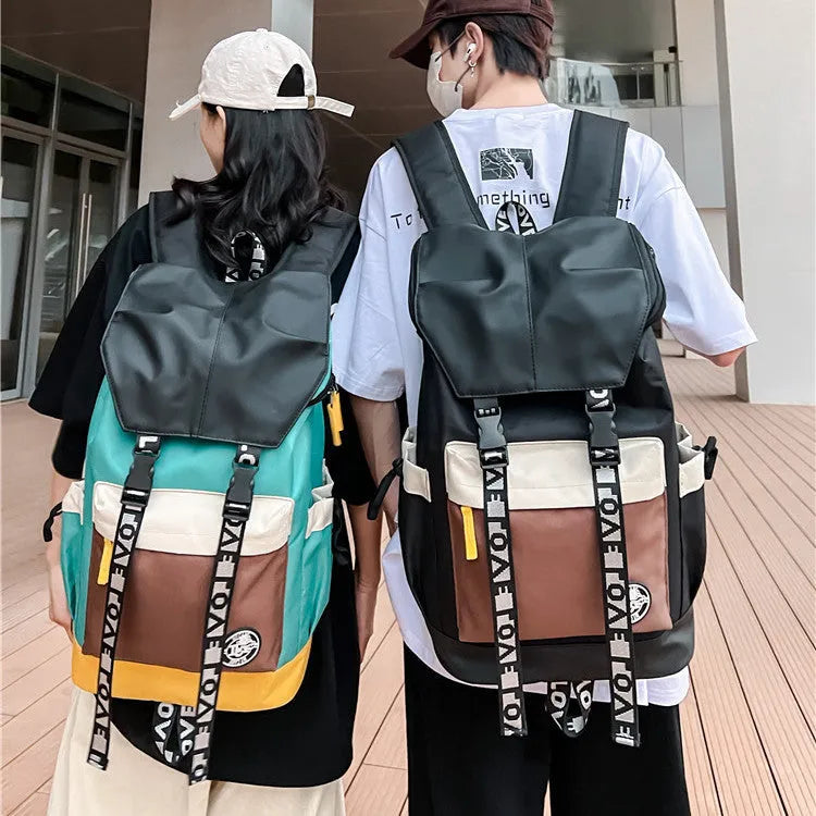 Oxford cloth backpack in black, green, or red with multiple carry handles and straps.