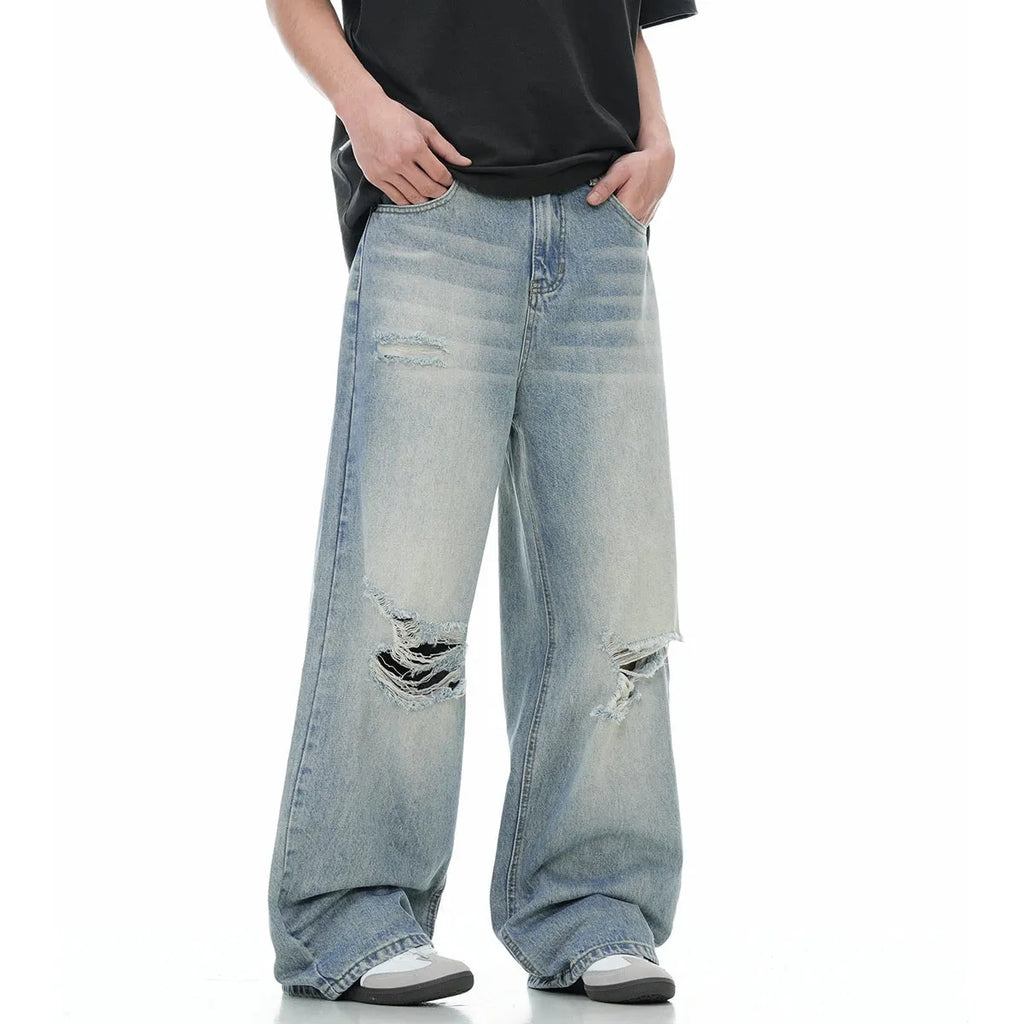 Blue men's straight-leg jeans with ripped details and a zip fly on a neutral background.