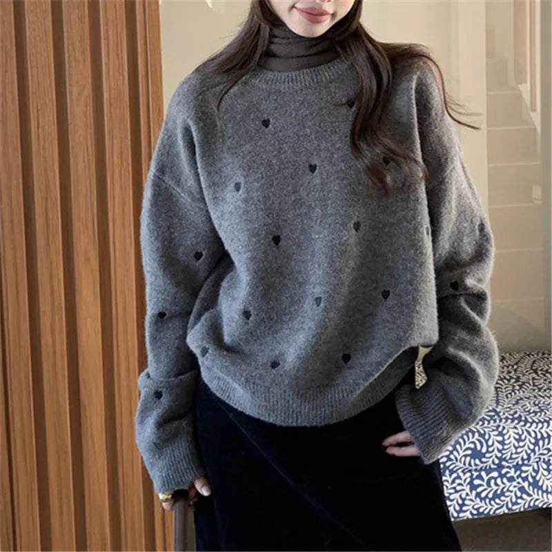 Women's loose grey acrylic pullover sweater with embroidery on the chest.