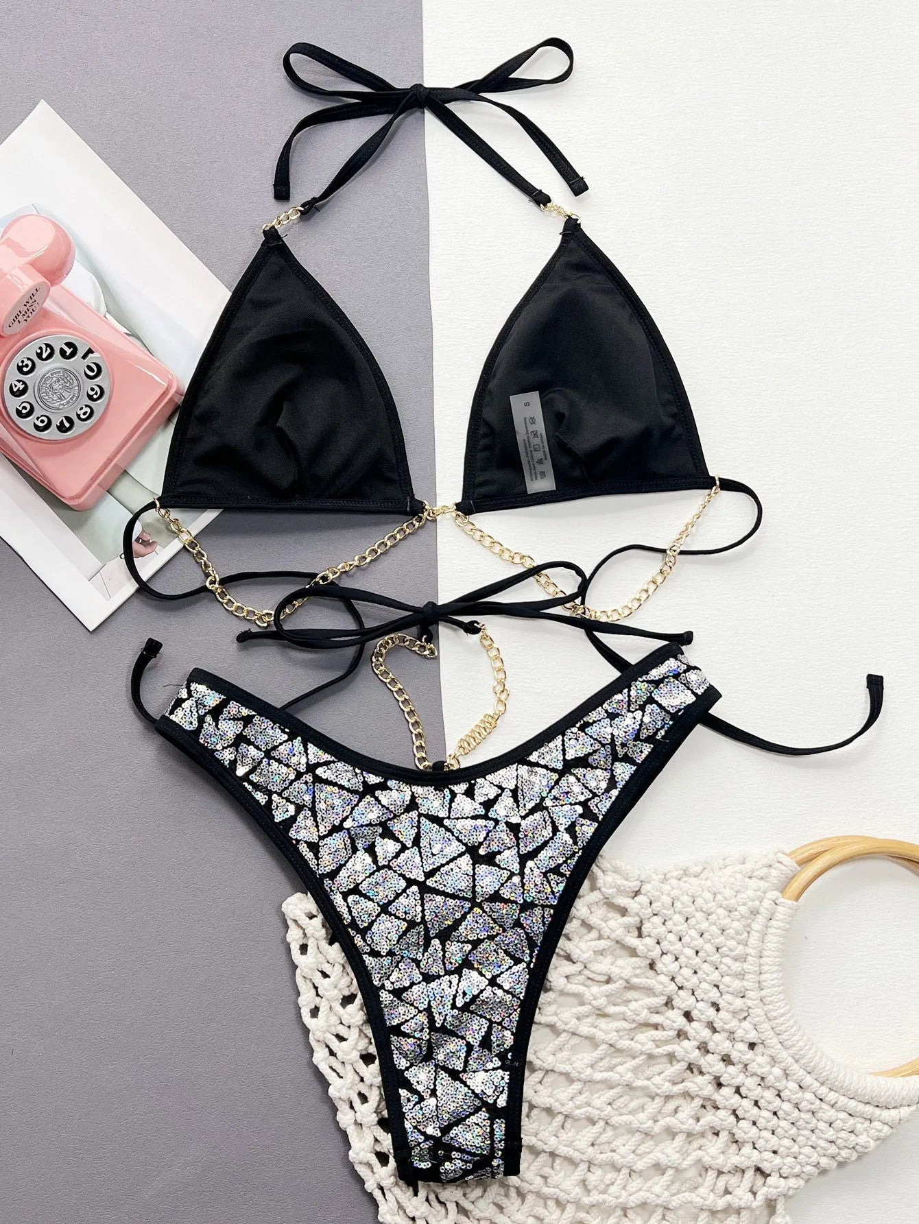 Women's silver black bikini swimsuit with chain detail, showing top and briefs.