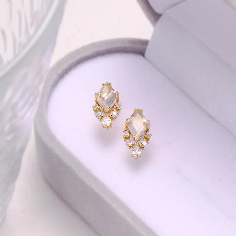 Geometric silver earrings with white crystal studs showing front detail