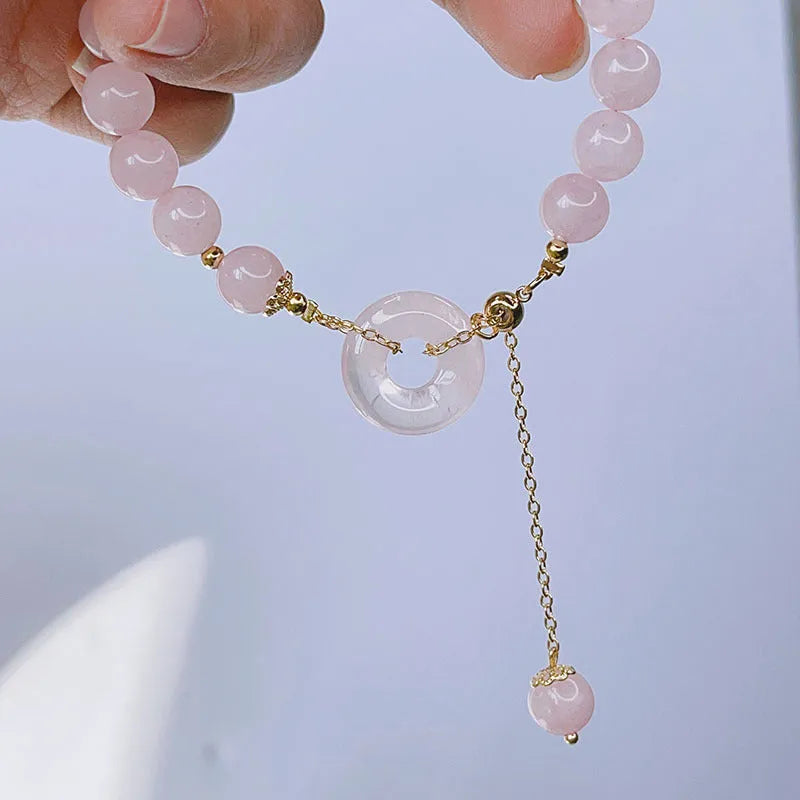 Pink crystal bracelet with peace buckle closure on woman's wrist