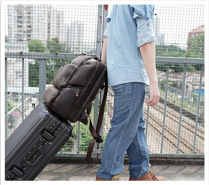 Dark brown genuine crazy horse leather backpack for men showing open pockets and organised internal compartments for a 17-inch laptop.