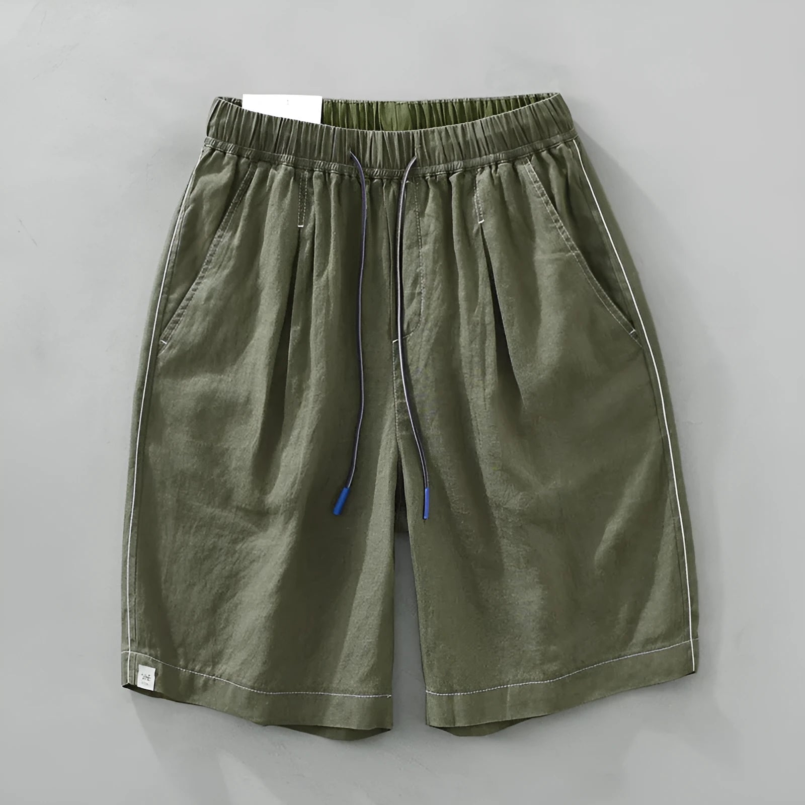 Men's loose fit linen shorts in green on a hanger, showing straight leg and drawstring waist.