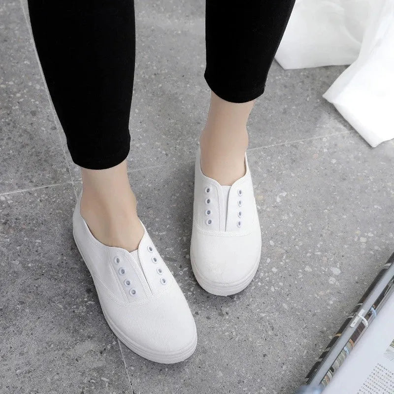 Low-top casual canvas shoes on a flat heel, shown in various colours including black, white, grey, and pink.