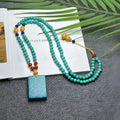 Turquoise mesh flower lucky pendant on a ball bead chain necklace, showing clasp.