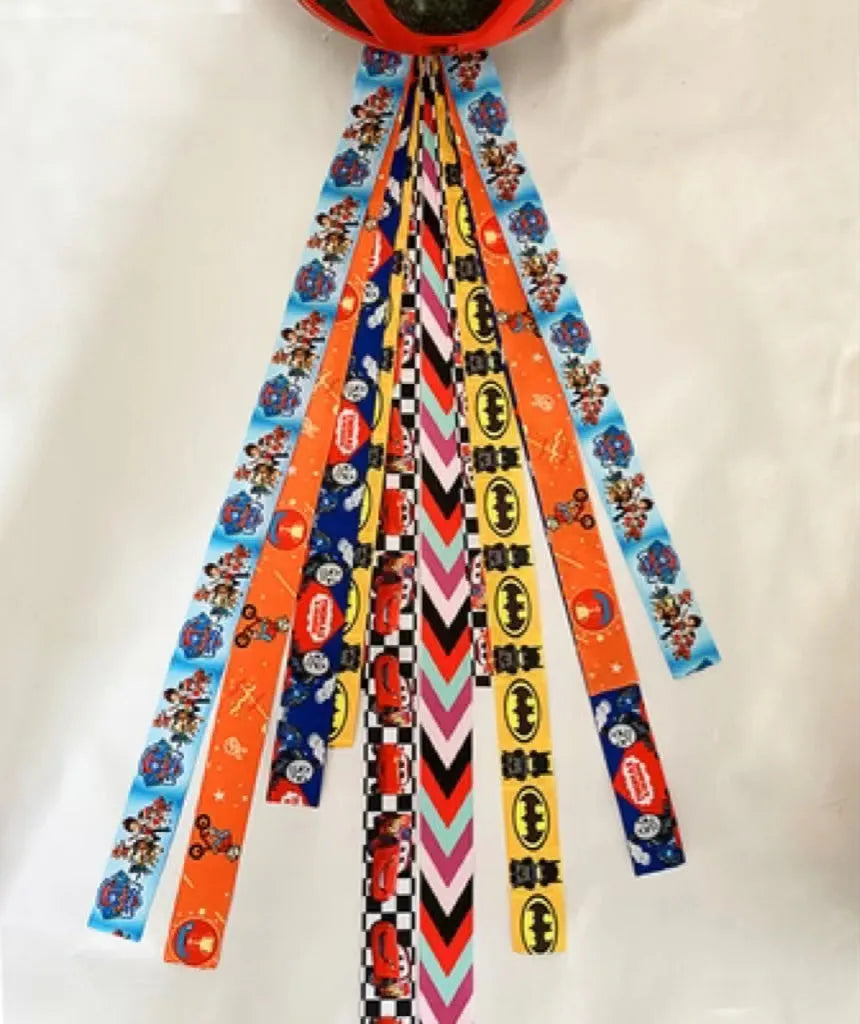 A decorative ribbon streamer for attaching to a child's roller skate or ski helmet, shown in a selection of colours.