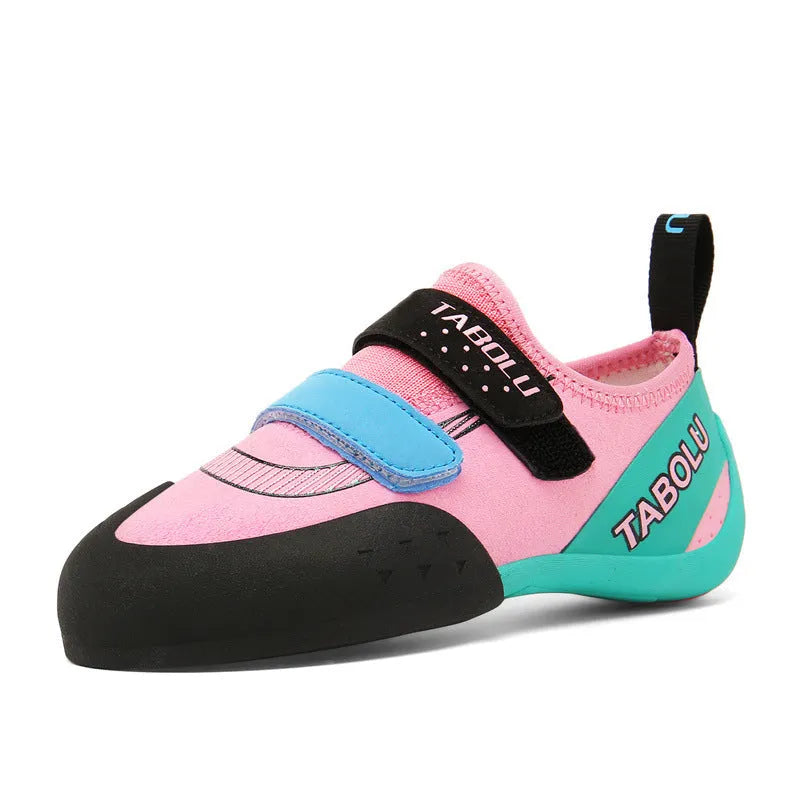 A pair of beginner rock climbing shoes with velcro straps in a black and red colour combination.