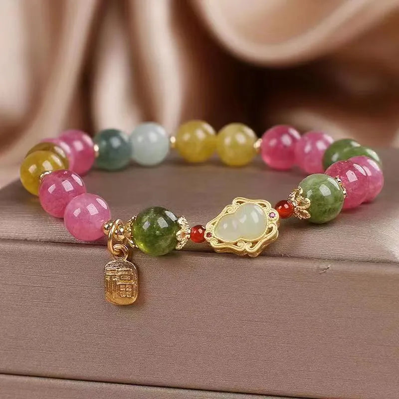 Close-up of a women's gourd blessing card bracelet with colourful tourmaline stones and electroplated finish.