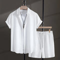 Men's white cotton blend beach suit with short sleeve shirt and loose-fitting shorts on a hanger.