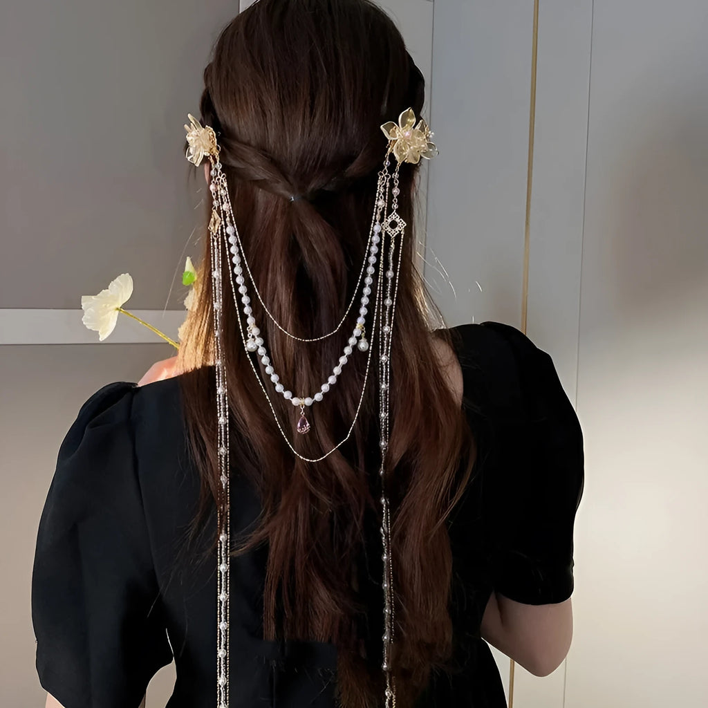 Women's decorative hairpin with pearl, diamond, and flower elements on long tassel with gold grip