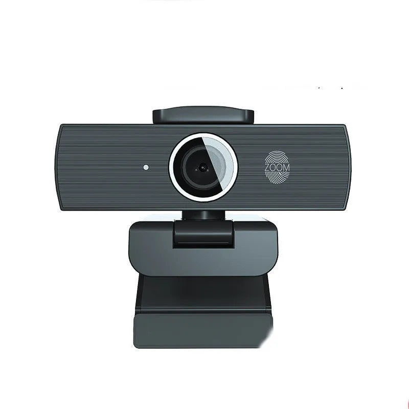 Black USB computer webcam with a magnetic privacy cover on a desk.