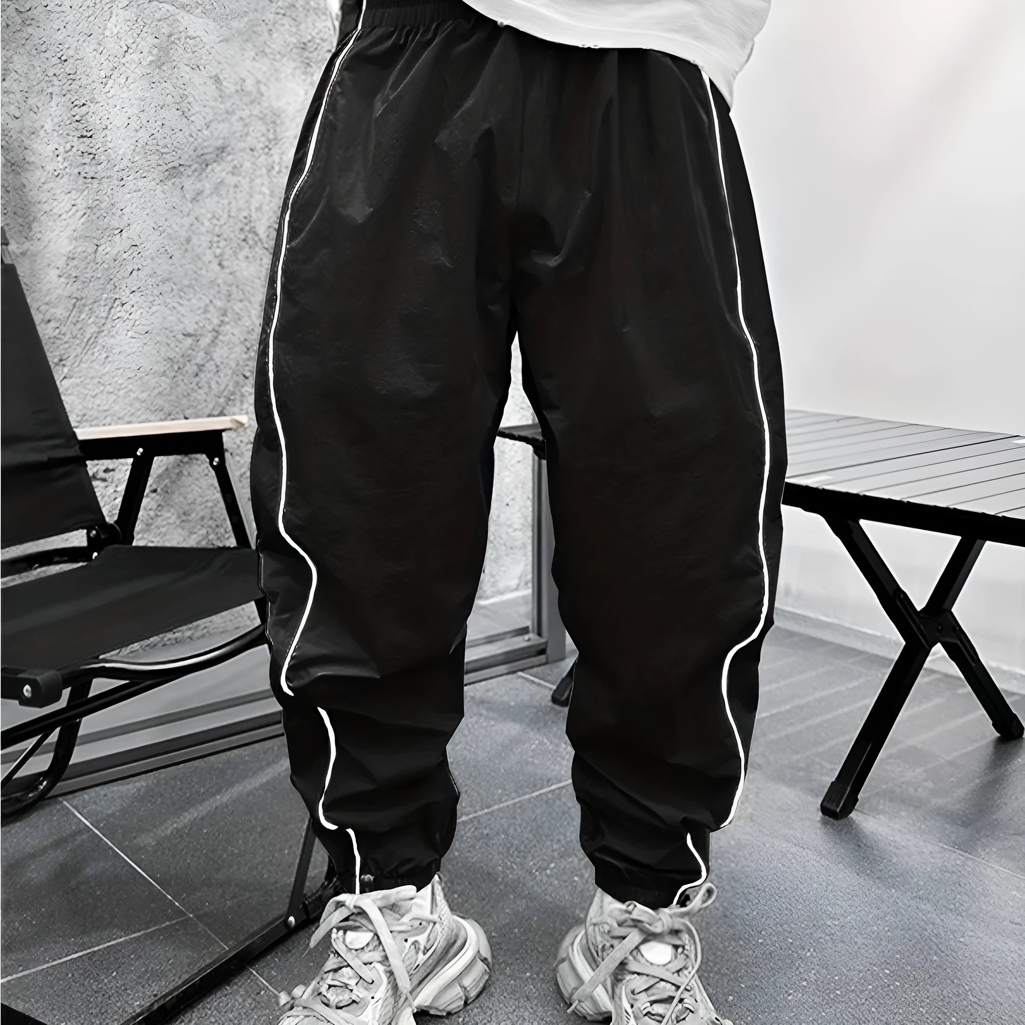 Man wearing loose-fit cropped sports trousers in bamboo fibre, showing army green colour and elastic waist.