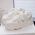 Beige children's platform trainers with cross shoulder straps and white laces on a 3cm thick rubber sole.