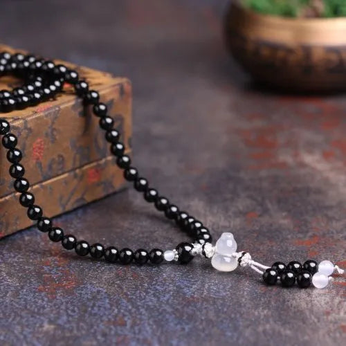 Natural red and black agate 108 bead prayer bracelet with geometric shapes.