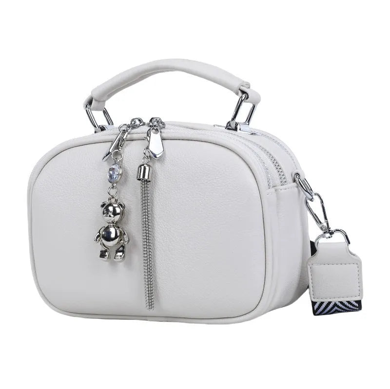 Oval-shaped women's small square handbag in PU with stitching detail and double straps.