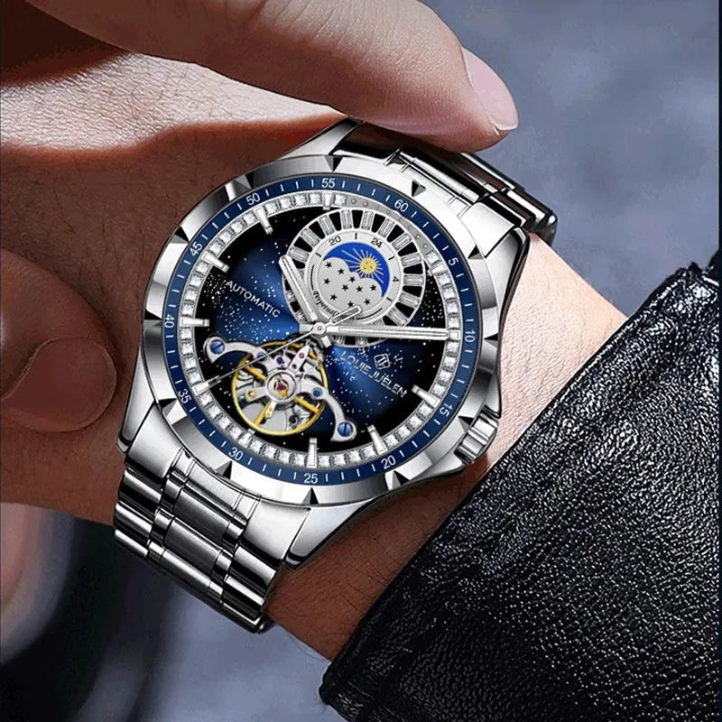 Silver men's automatic watch with a blue dial and stainless steel strap on a wrist