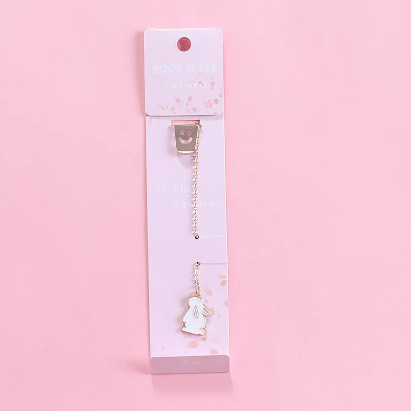 Cartoon-themed alloy metal bookmark charm on a book page.