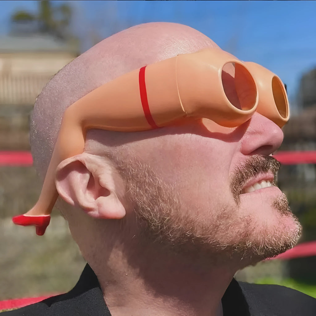 Orange plastic sunglasses with wide lenses on a white background, showing adjustable leg hip design.
