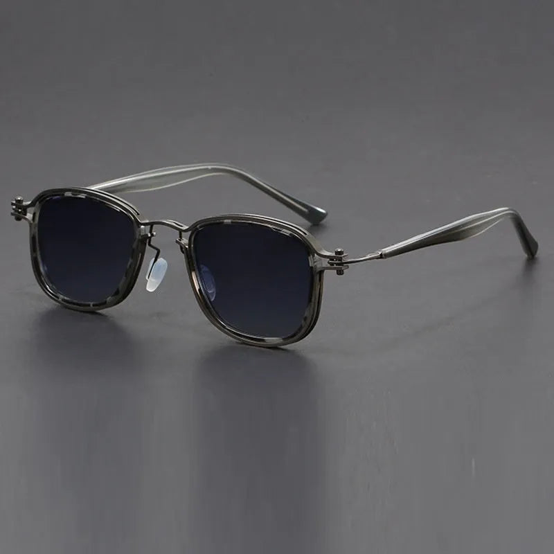 Retro square sunglasses with metal frame and tinted AC lenses in a two-tone colour option on a wooden surface.