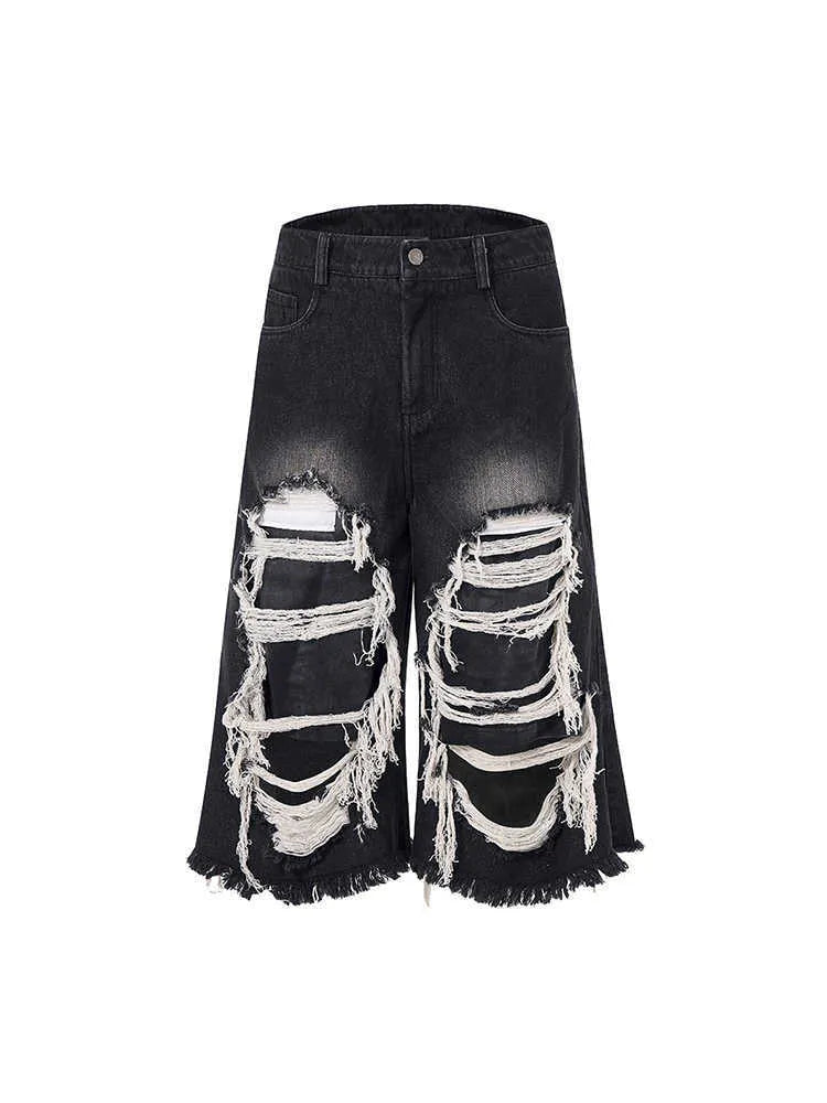 Black wide-leg cropped jeans with distressed patchwork detail and a mid-high waist.