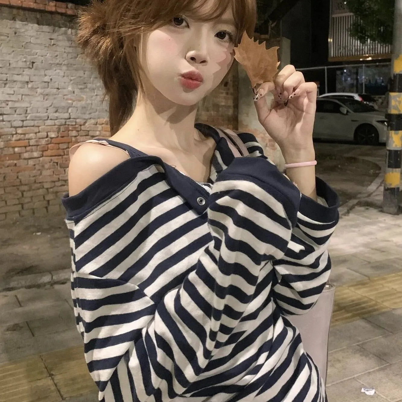 Dark blue women's oversized long-sleeve T-shirt with embroidered stripes and button details.