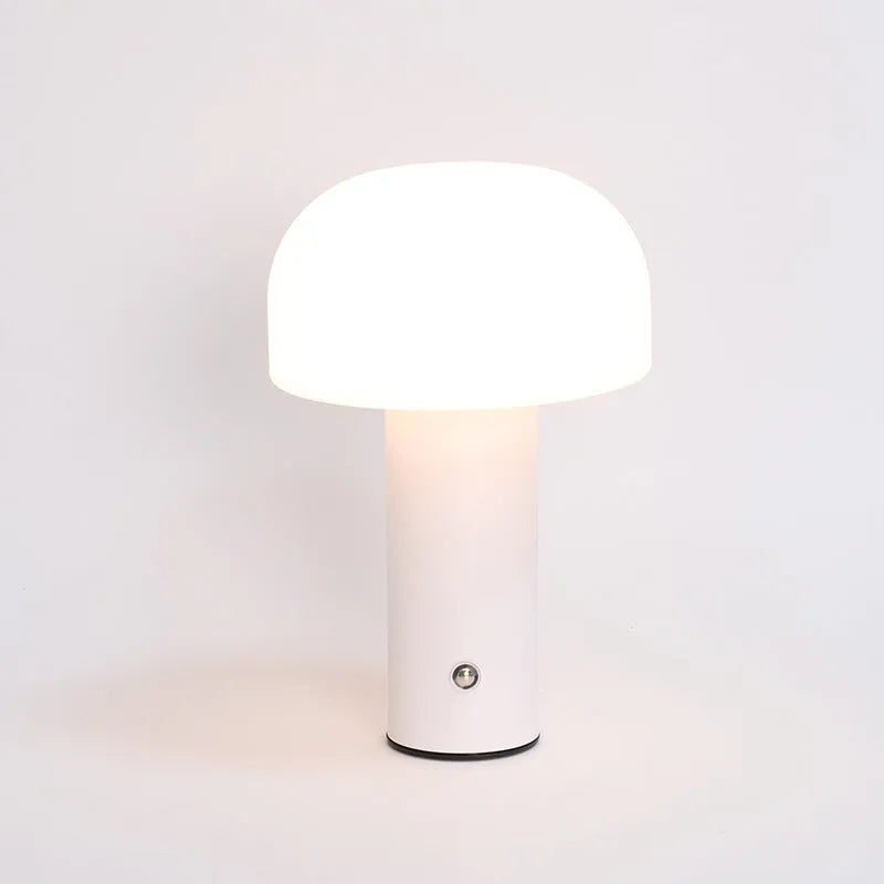 White plastic USB table lamp with integrated charging port on a wooden desk.
