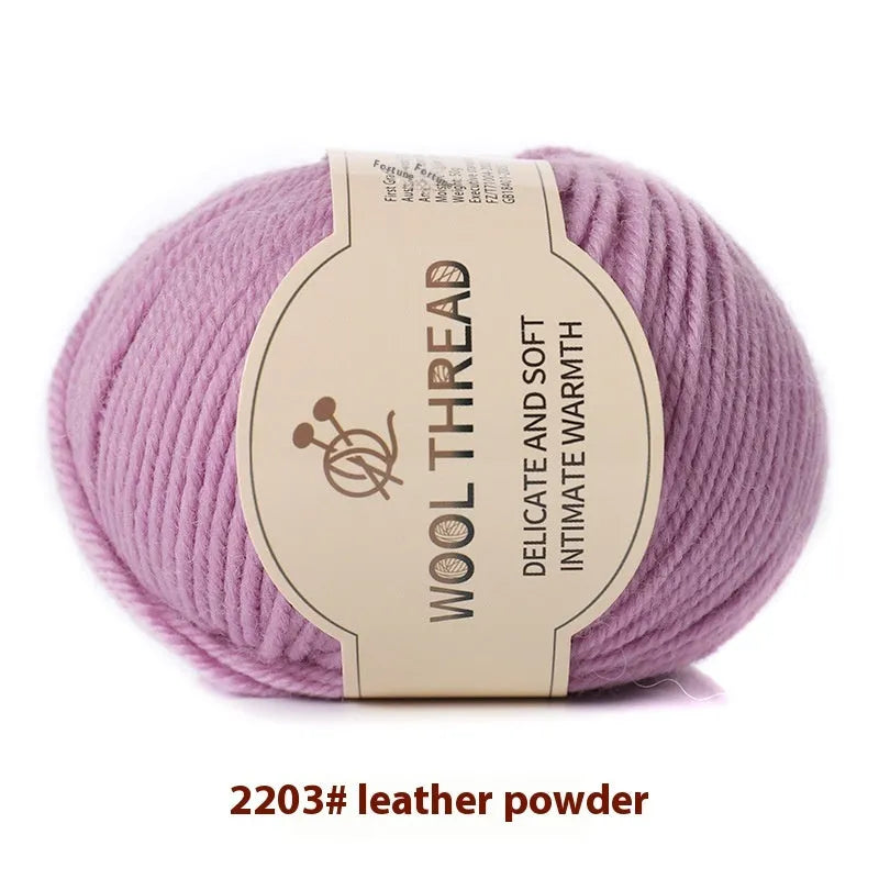 One roll of beige domestic wool hand-knitting yarn for size 10 needles next to knitting needles.