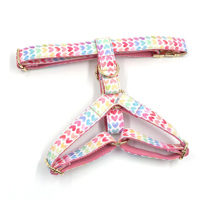 Pink dog harness with gold buckle and colourful heart-shaped stone decoration in four adjustable sizes