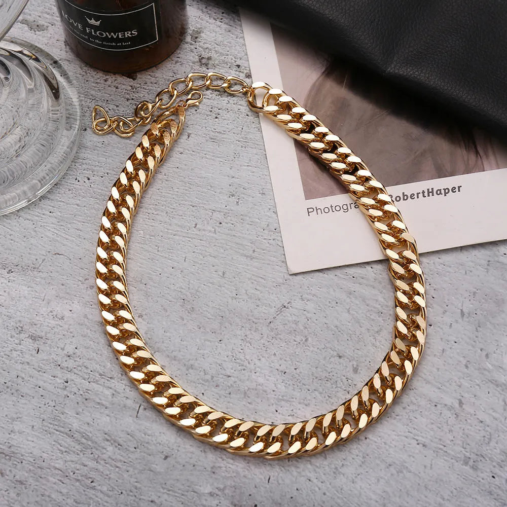 Gold-toned women's thick chain necklace with an integrated rectangular pendant, shown on a plain background.