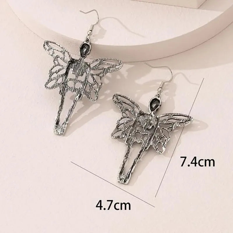 Pair of silver-coloured alloy earrings with exaggerated skull design on white background