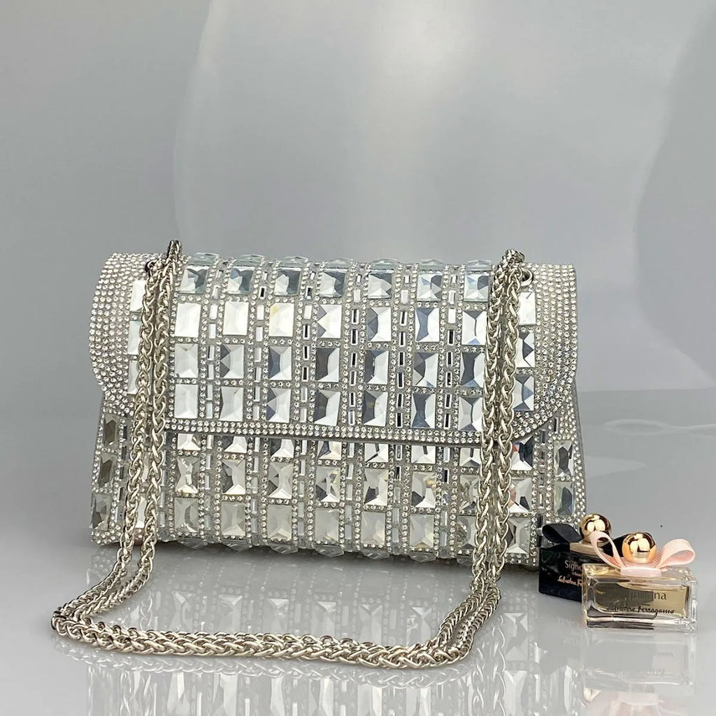 Silver rhinestone chain clutch purse with a horizontal square shape and open pocket.