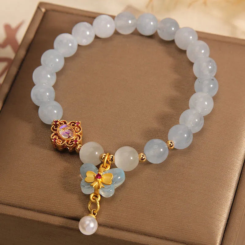 Women's crystal bracelet with aquamarine butterfly pendant and rhinestone details