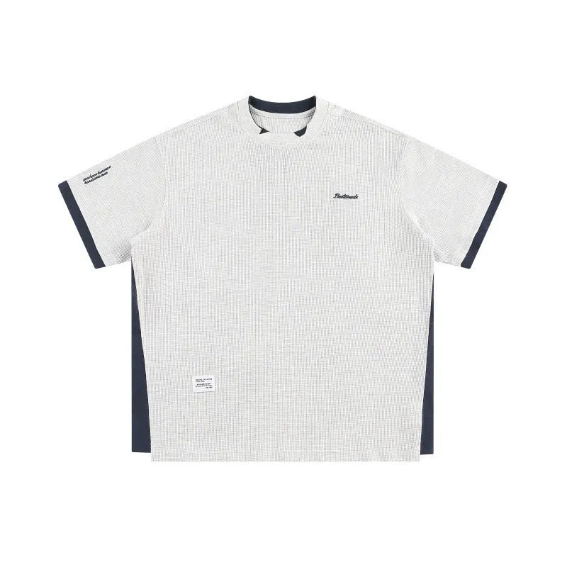 Loose grey waffle-texture T-shirt with embroidered retro alphabet design on the front.