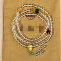 White crystal 108-bead rosary necklace and matching bracelet set on a plain background
