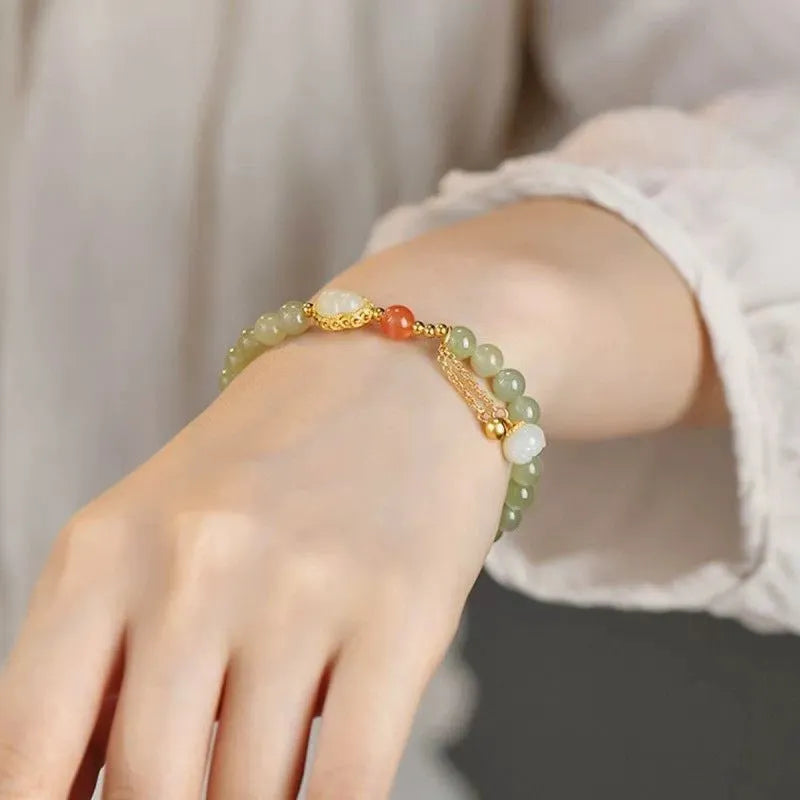 Natural jade bead bracelet with a gold-plated gourd charm and fu character.