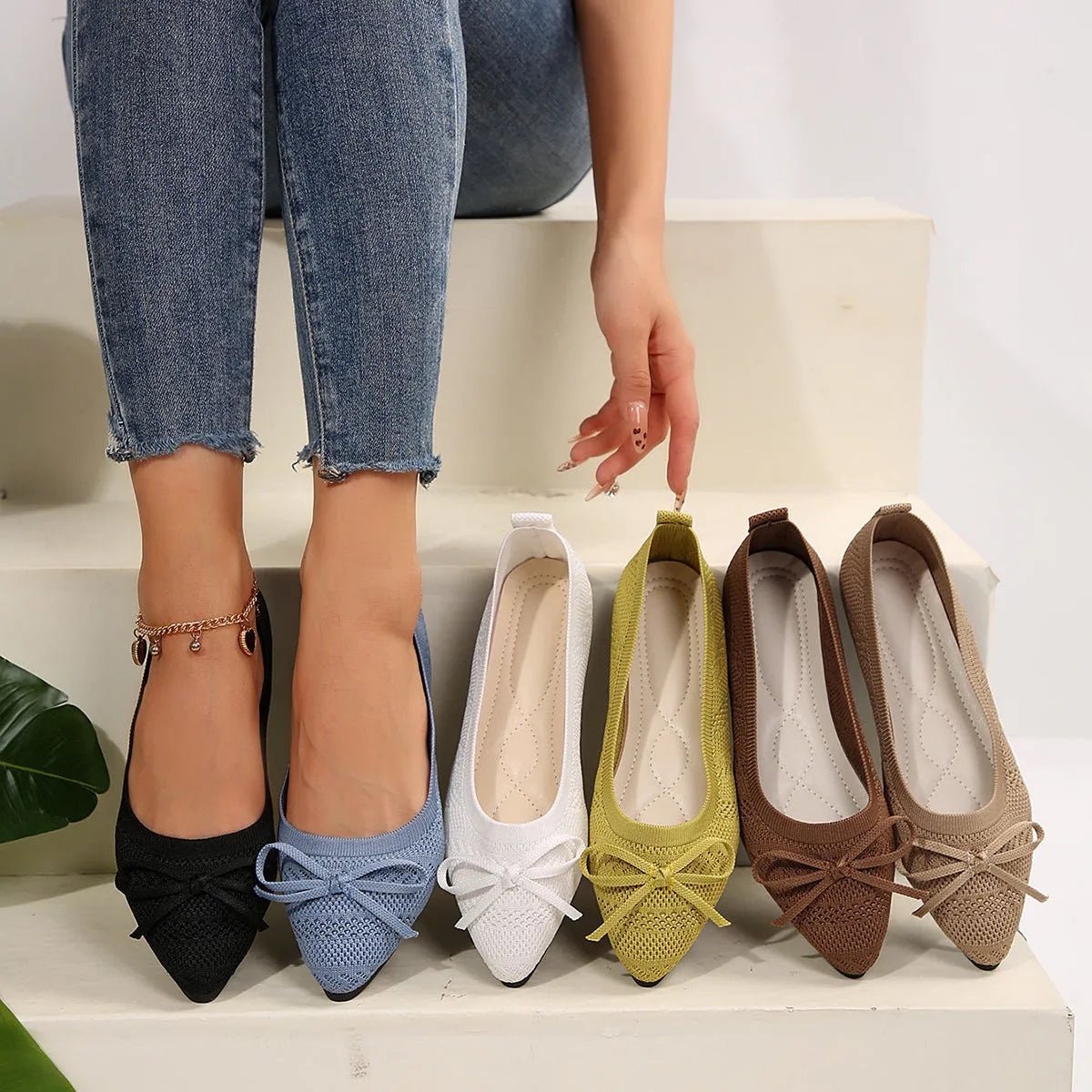 Women's blue knitted flat loafers with a pointed toe and a decorative bow on the front