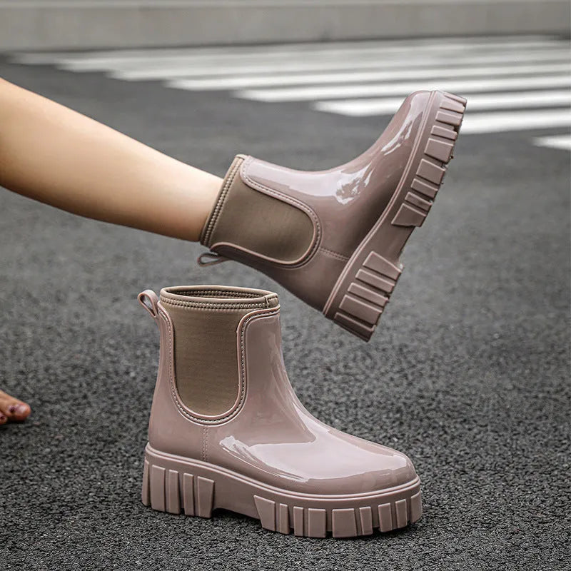 A pair of low tube, flat-heeled PVC rain boots in a solid colour.