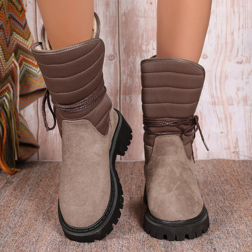 Women's black chunky heel snow boot with suede upper and lace-up design.